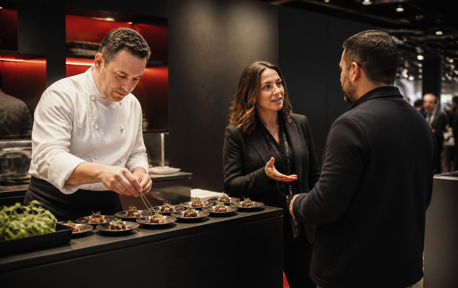Foodservice professionals presenting products at a food trade show booth